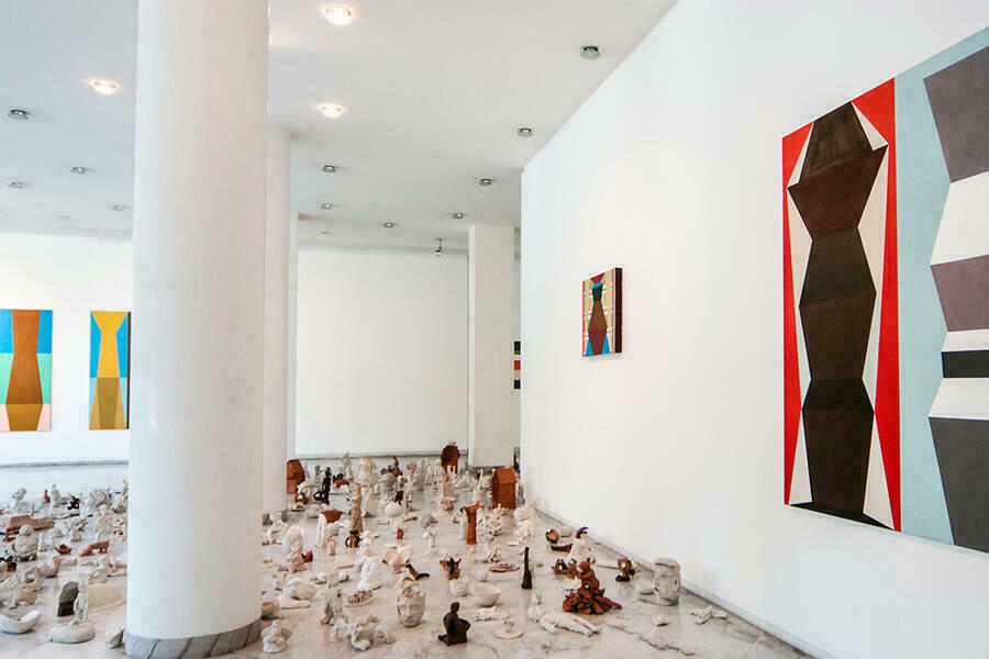 Blick in eine Ausstellung in der Galerie des Bezirks Oberbayern. An den Wnden abstrakte Bilder am Boden der galeire kleine Skultprue aus Ton