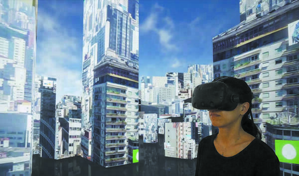 Eine Frau im einem VR-Headset steht inmitten einer virtuellen Landschaft aus Hochhäusern