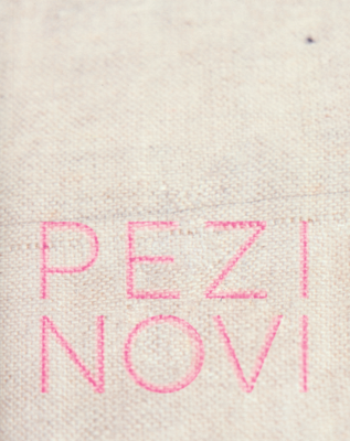 Titelbid eines Kataloges mit der Aufschrift "Pezi Novi" in rot auf einem Grund mit Stoffstruktur